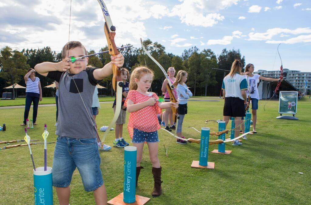 Image of kids lining up with archery bows