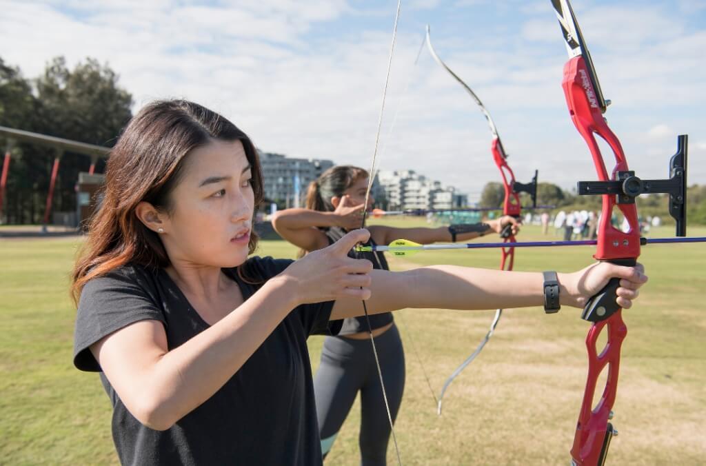 People drawing an archery bow